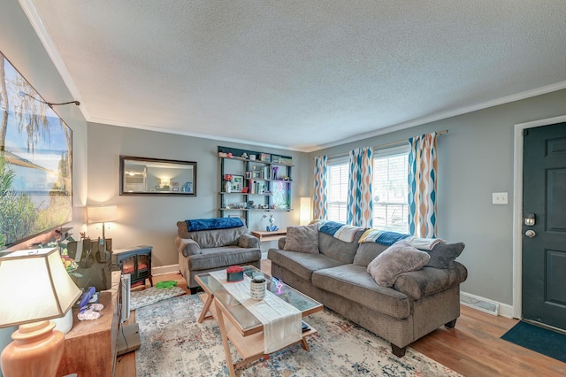 living room with crown molding, a textured ceiling, and light wood-type flooring