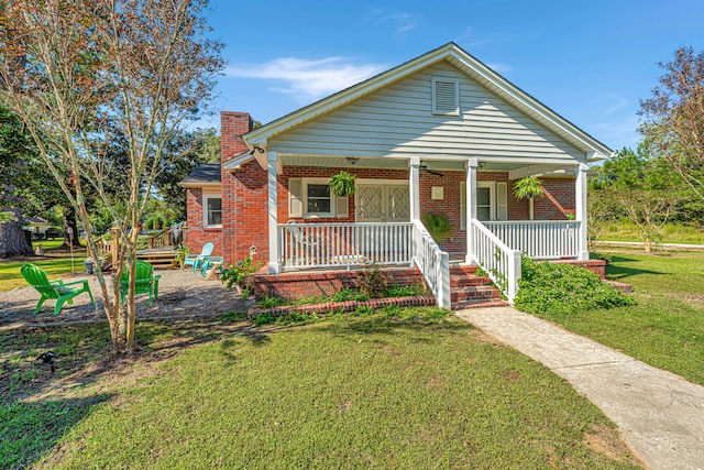 bungalow featuring covered porch and a front lawn