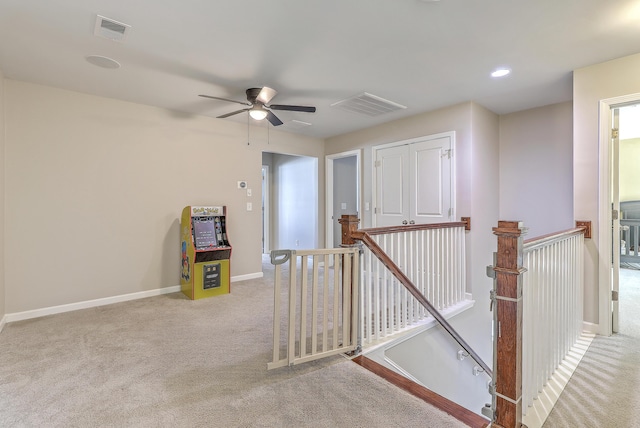 interior space with visible vents, carpet flooring, baseboards, and ceiling fan