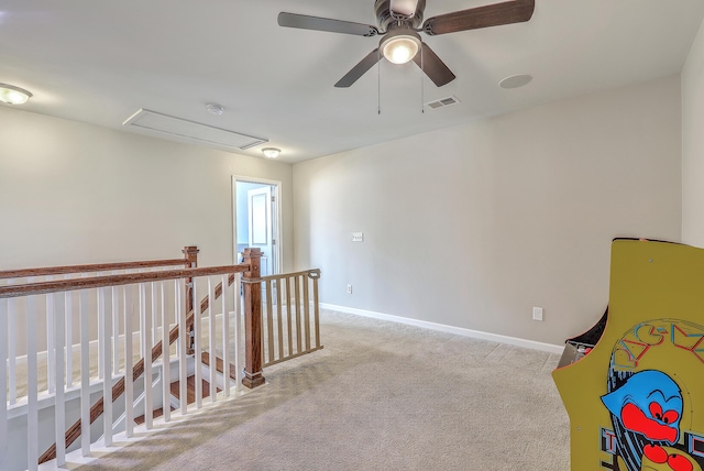 unfurnished room featuring carpet, attic access, baseboards, an upstairs landing, and visible vents