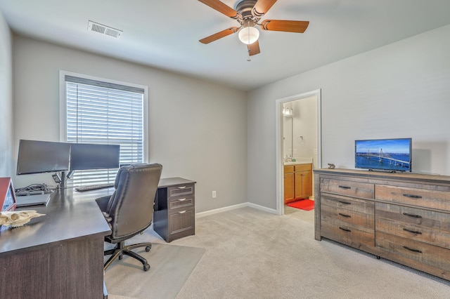 office featuring visible vents, baseboards, ceiling fan, and light colored carpet