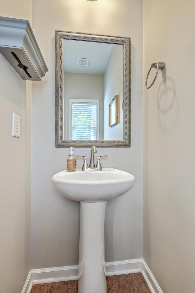 bathroom with baseboards, visible vents, and wood finished floors