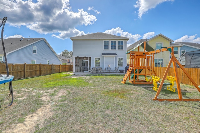 rear view of house featuring a patio, a playground, a fenced backyard, and a sunroom