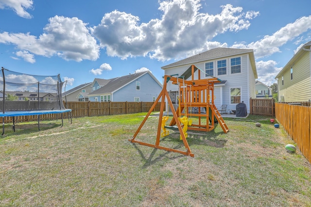 view of play area with a lawn, a trampoline, and a fenced backyard