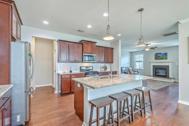 kitchen with ceiling fan, a sink, dark wood finished floors, stainless steel appliances, and visible vents