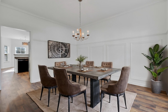 dining room with crown molding, a chandelier, and wood-type flooring