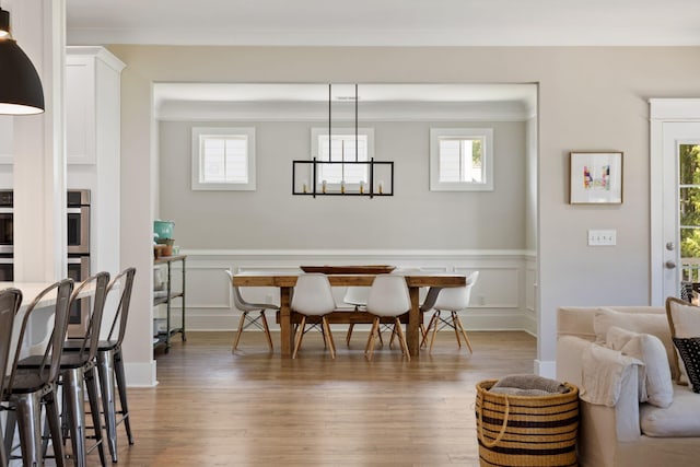 2828 Wagner Way, Mount Pleasant, SC 29466 - dining area featuring a wainscoted wall, healthy amount of natural light, wood finished floors, a decorative wall, and ornamental molding