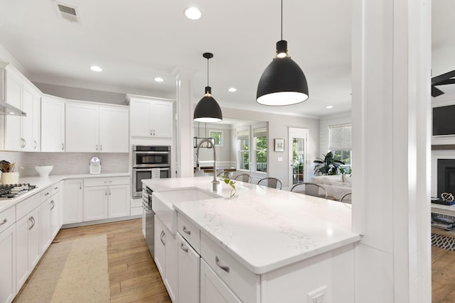 2828 Wagner Way, Mount Pleasant, SC 29466 - kitchen with recessed lighting, light wood finished floors, stainless steel appliances, tasteful backsplash, and white cabinets