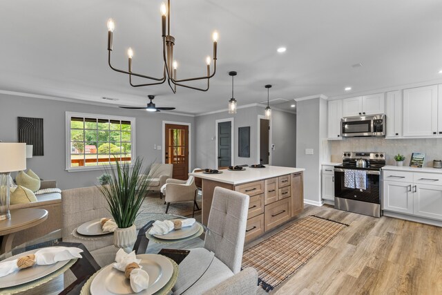 dining space featuring ornamental molding, light wood-style flooring, a chandelier, ceiling fan, and recessed lighting