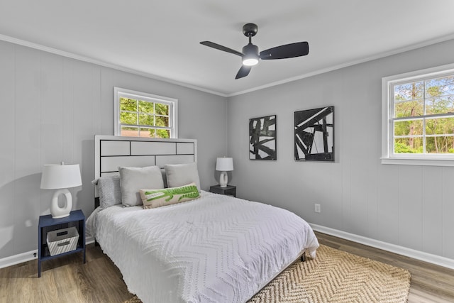 bedroom with wood finished floors, baseboards, ornamental molding, and a ceiling fan