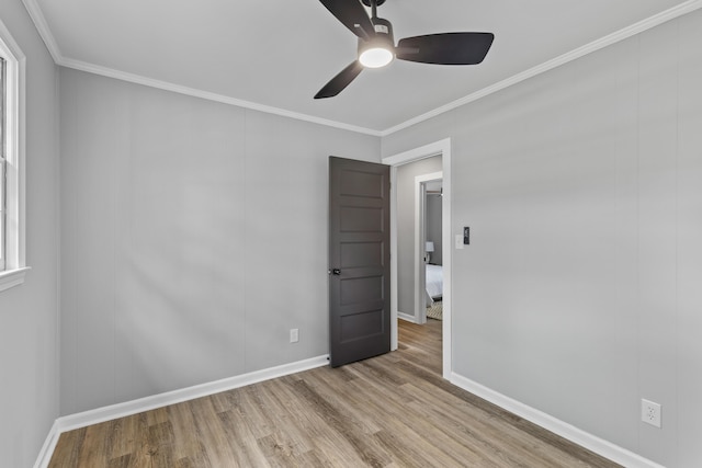 unfurnished bedroom featuring wood finished floors, ornamental molding, baseboards, and ceiling fan