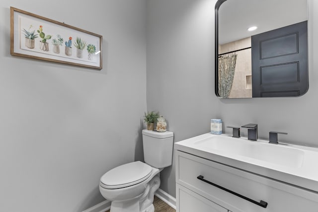 full bathroom featuring toilet, baseboards, vanity, and curtained shower