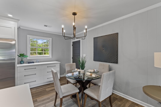 dining space featuring dark wood finished floors, ornamental molding, a chandelier, and baseboards