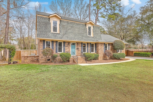 dutch colonial featuring a front lawn, fence, brick siding, and roof with shingles