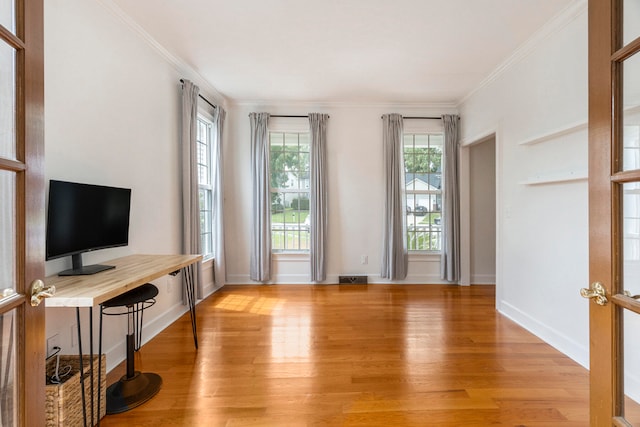 interior space with light wood-type flooring, french doors, and ornamental molding