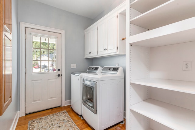 laundry room featuring light wood-type flooring, cabinets, and independent washer and dryer