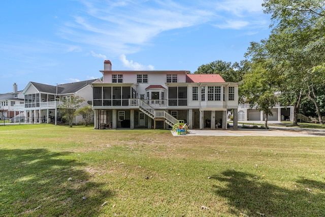 rear view of property with a sunroom and a lawn