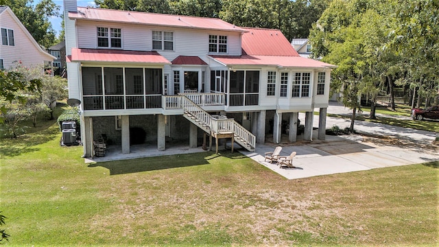 rear view of house with a patio area, a yard, and a sunroom