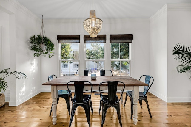 dining area with light wood-type flooring, plenty of natural light, and crown molding