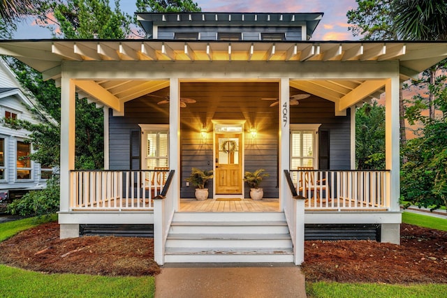 exterior entry at dusk featuring covered porch