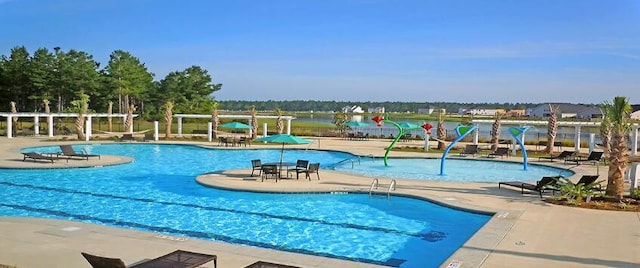 view of swimming pool featuring a water view and a patio