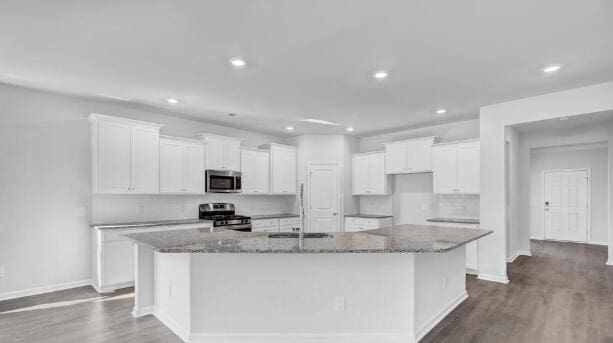 kitchen featuring white cabinets, dark hardwood / wood-style floors, an island with sink, and stainless steel appliances