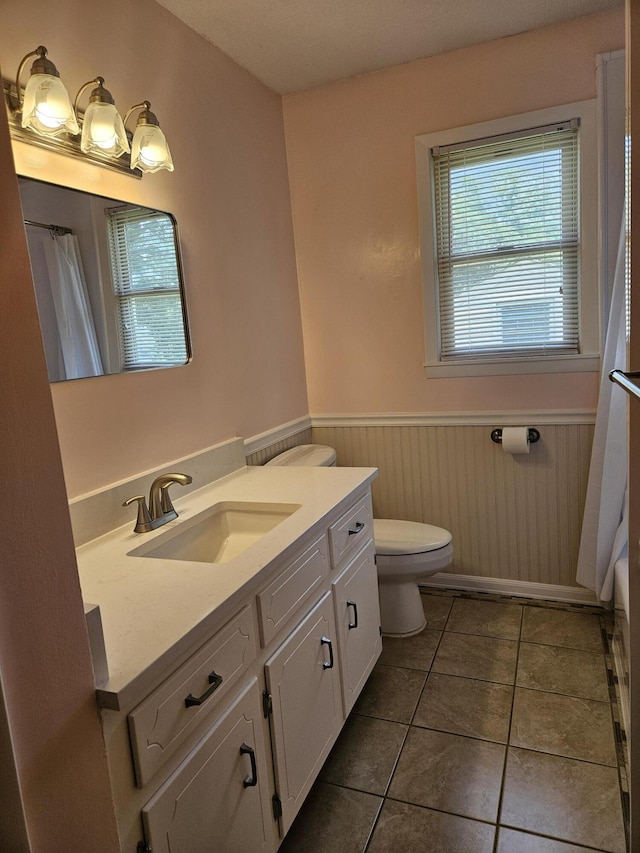 101 Brittany Ct, Summerville, SC 29485 - bathroom featuring vanity, a wainscoted wall, toilet, tile patterned flooring, and a shower with curtain
