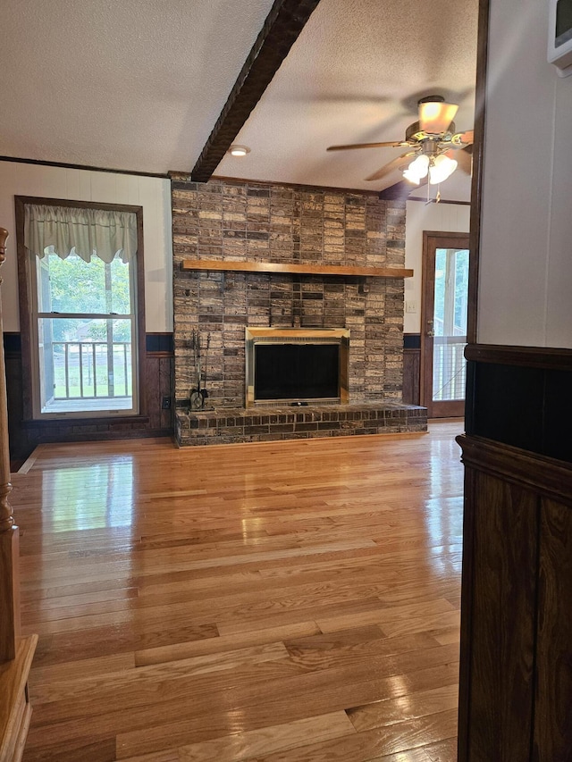 101 Brittany Ct, Summerville, SC 29485 - unfurnished living room with a large fireplace, a textured ceiling, ceiling fan, beam ceiling, and wood finished floors