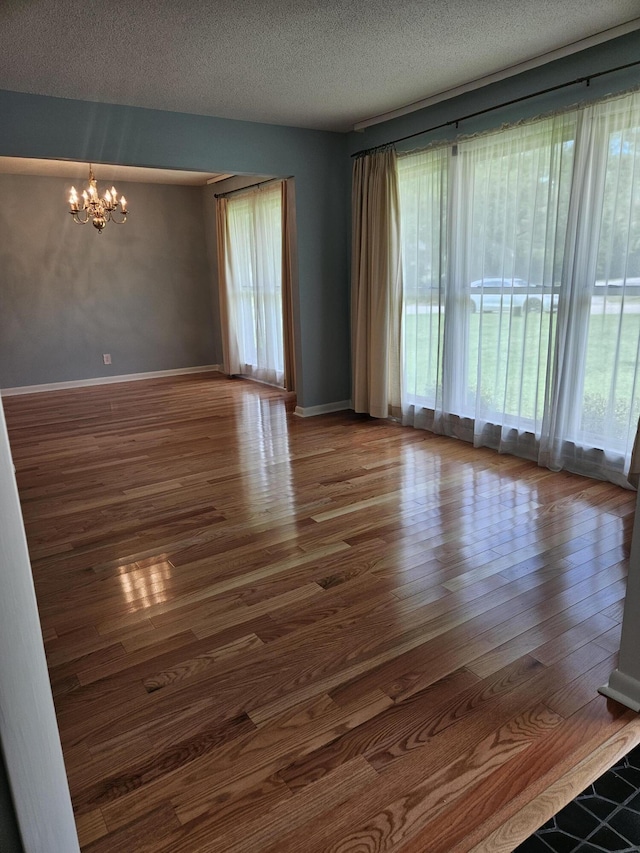 101 Brittany Ct, Summerville, SC 29485 - empty room featuring a chandelier, healthy amount of natural light, wood finished floors, a textured ceiling, and baseboards