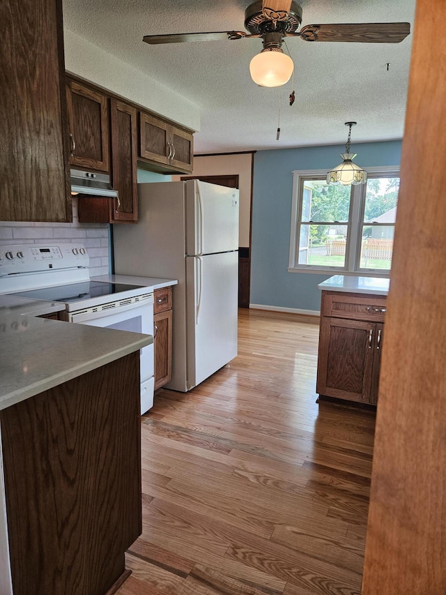 101 Brittany Ct, Summerville, SC 29485 - kitchen with white appliances, light wood-style flooring, under cabinet range hood, a textured ceiling, and a ceiling fan