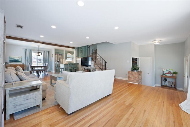 living area with stairway, recessed lighting, visible vents, and light wood-type flooring