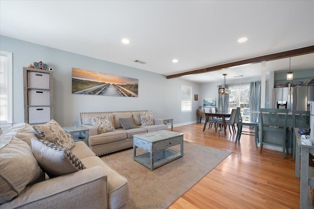 living room featuring beamed ceiling, recessed lighting, baseboards, and light wood finished floors