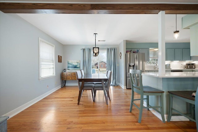 dining area featuring visible vents, light wood-style floors, and baseboards