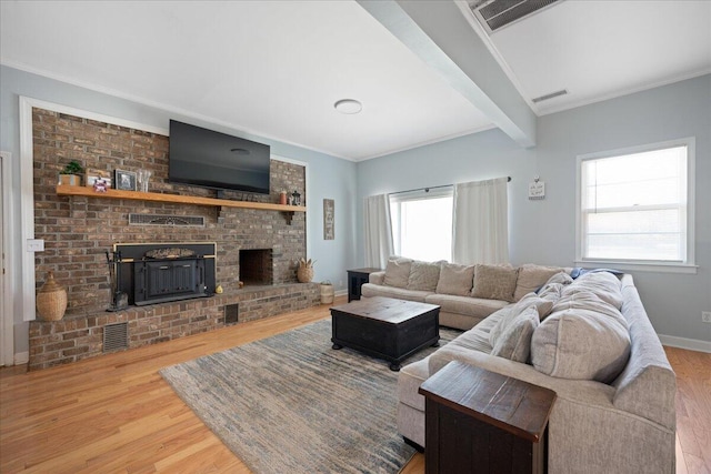 living room with visible vents, ornamental molding, baseboards, and wood finished floors