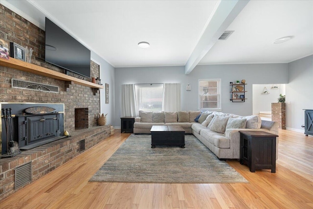 living area featuring visible vents, beam ceiling, wood finished floors, crown molding, and baseboards