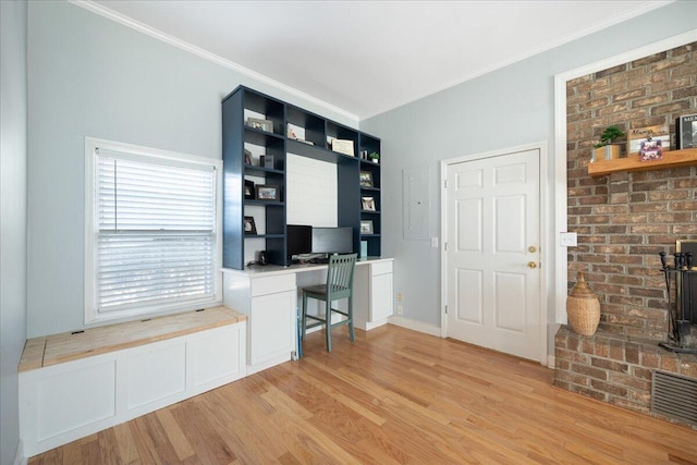 office space with crown molding, light wood-style flooring, and visible vents