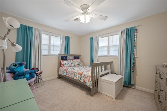 bedroom featuring multiple windows, light carpet, and baseboards