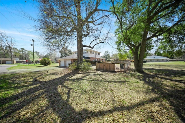 view of yard featuring fence and a garage