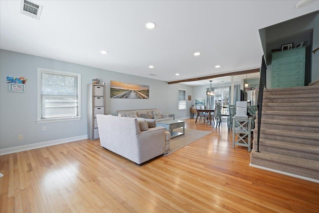 living room with recessed lighting, visible vents, light wood-style flooring, and stairway