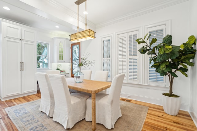 dining area with light wood-type flooring and crown molding