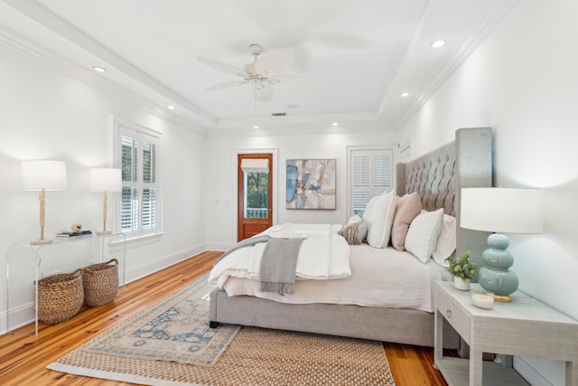 bedroom featuring ceiling fan, a tray ceiling, and hardwood / wood-style flooring