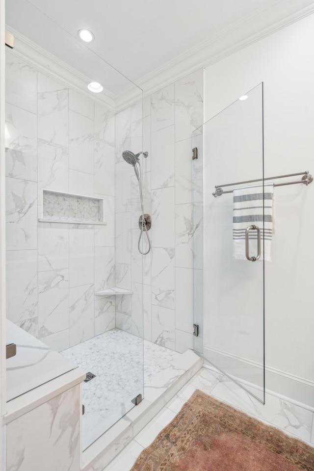 bathroom featuring a shower with door and crown molding