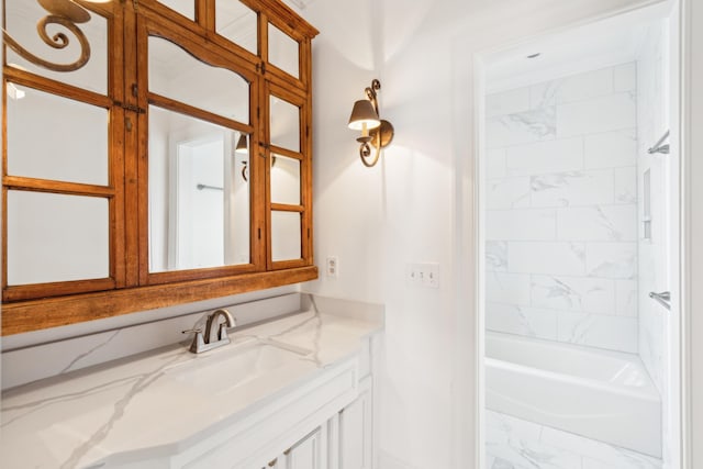 bathroom featuring tiled shower / bath combo and vanity