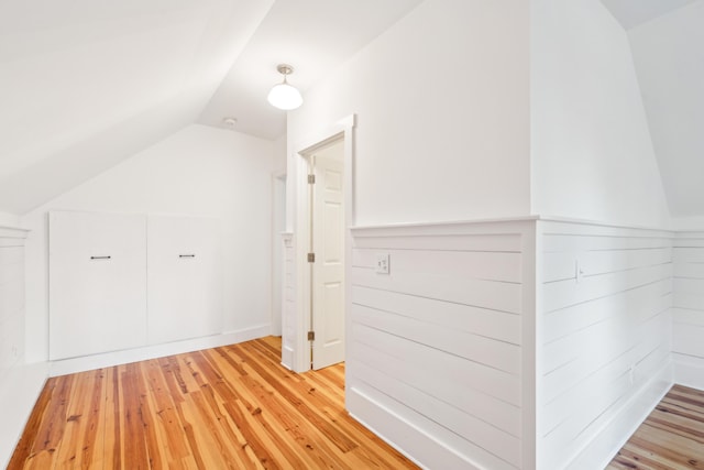 bonus room with lofted ceiling and light hardwood / wood-style flooring