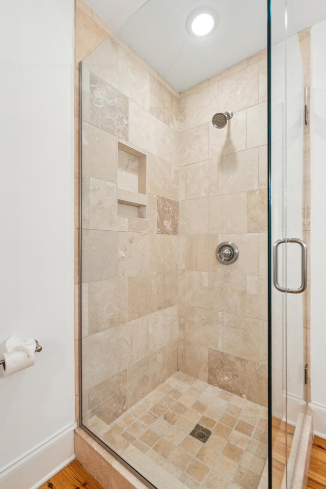 bathroom with hardwood / wood-style floors and a shower with door