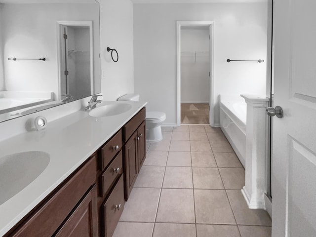 bathroom with tile patterned flooring, vanity, toilet, and a bathing tub