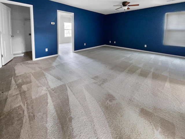 carpeted spare room featuring ceiling fan