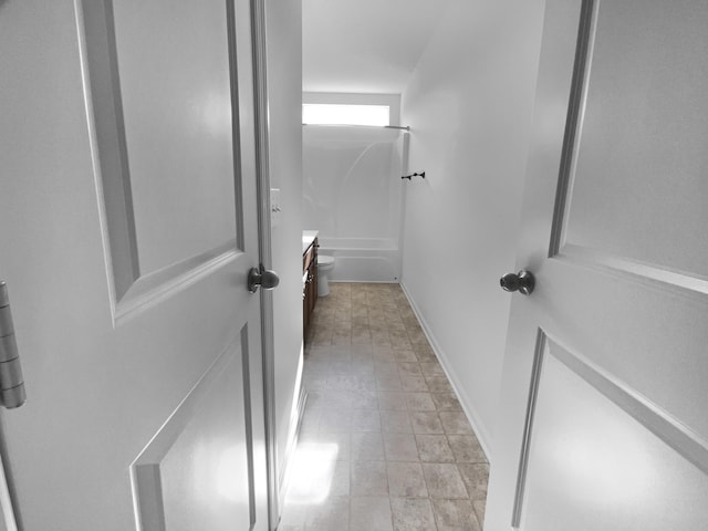 interior space featuring vanity, tub / shower combination, and toilet