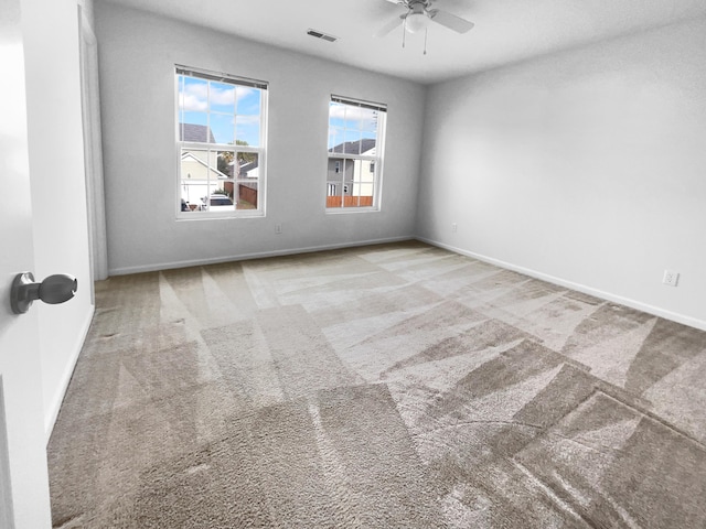 carpeted spare room with ceiling fan