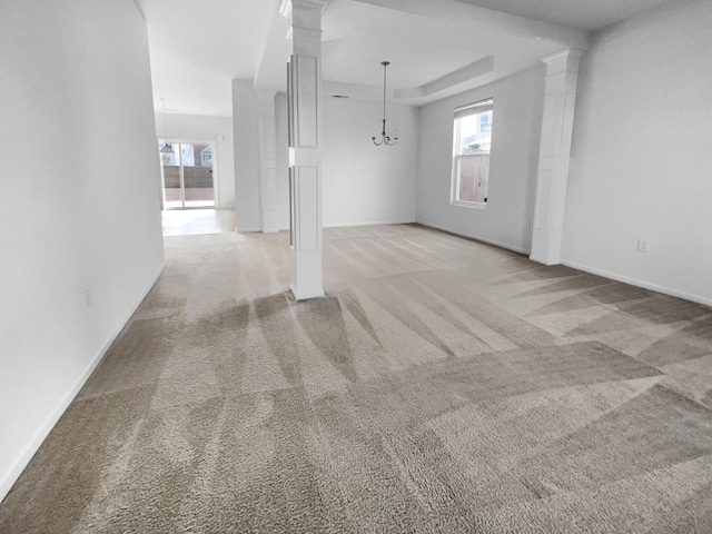 interior space with plenty of natural light, a raised ceiling, light carpet, and a chandelier